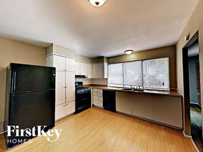 Florissant house for rent - a kitchen with black appliances and a wood floor