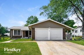 Florissant house for rent - a white garage door in front of a brick house
