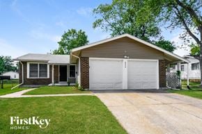 Florissant house for rent - a white garage door in front of a brick house