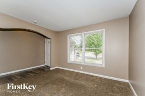 Florissant house for rent - a bedroom with a large window and a carpeted floor