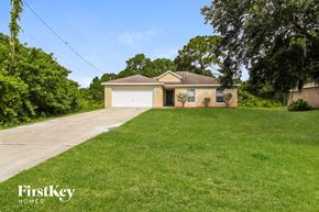 North Port house for rent - a yellow house with a garage and a lawn