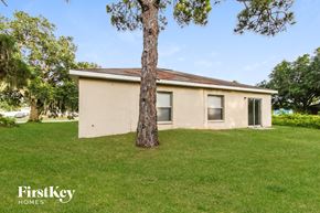 North Port house for rent - a small tan house with a tree in the grass