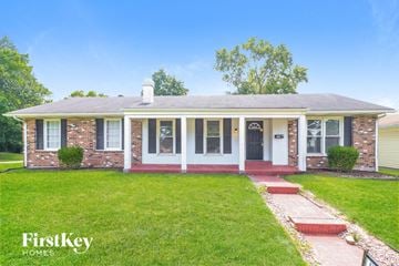 Florissant house for rent - a small brick house with a lawn and a porch