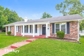 Florissant house for rent - a small brick house with a porch and a lawn