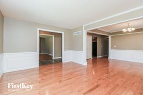 Florissant house for rent - an empty living room with wood floors and white walls