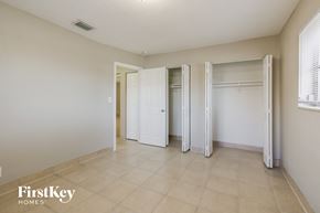 Lauderdale Lakes house for rent - a bedroom with three closets and a tiled floor and white doors