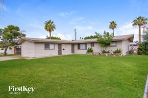 Phoenix house for rent - a white house with a yard and palm trees