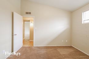 Phoenix house for rent - a bedroom with white walls and carpet and a door to a hallway