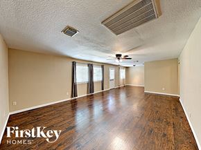 Spring house for rent - an empty living room with wood floors and a ceiling fan