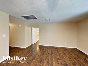 Spring house for rent - an empty living room with wood flooring and white walls