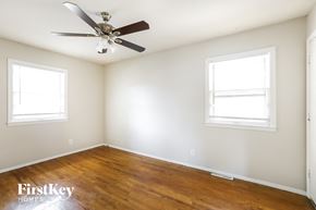 Independence house for rent - a bedroom with wood floors and a ceiling fan