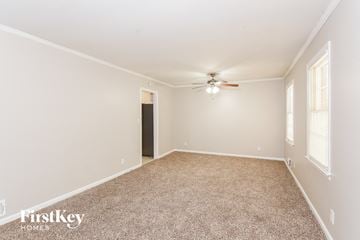 College Park house for rent - a spacious living room with carpet and a ceiling fan