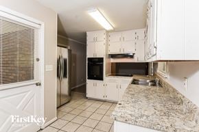College Park house for rent - a kitchen with white cabinets and a granite counter top
