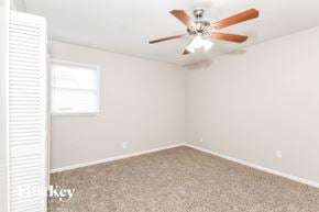 College Park house for rent - a bedroom with a ceiling fan and a window