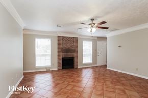 Humble house for rent - a living room with a fireplace and a ceiling fan