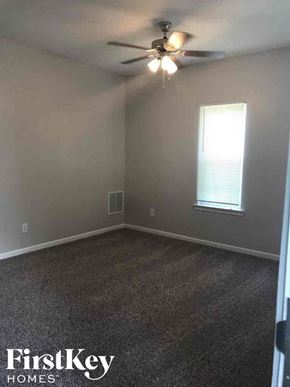 Atlanta house for rent - A room with a ceiling fan and a window.