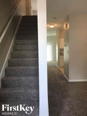 Atlanta house for rent - A staircase with a carpeted floor and a wall with a door.