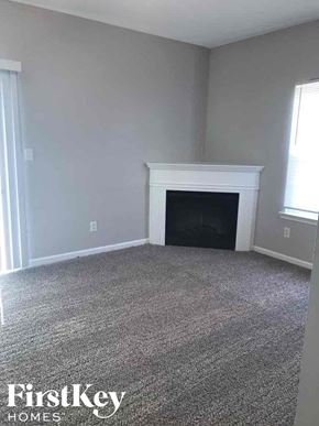 Atlanta house for rent - A room with a fireplace and a carpeted floor.