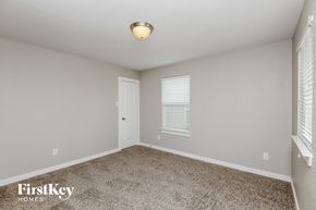 Dallas house for rent - a bedroom with a carpeted floor and a white door and window