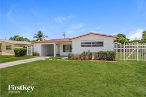 Lauderdale Lakes house for rent - a house with a yard and a white fence