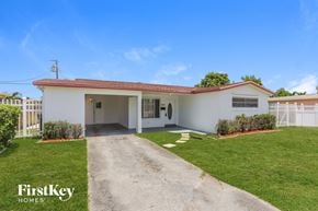 Lauderdale Lakes house for rent - a white house with a driveway and a lawn