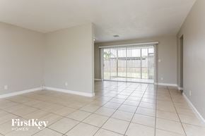 Lauderdale Lakes house for rent - an empty living room with a sliding glass door to a patio