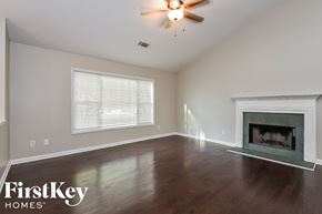 Kennesaw house for rent - A room with a fireplace and a ceiling fan.