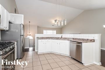 Kennesaw house for rent - A kitchen with a stove top oven, refrigerator, and a sink.