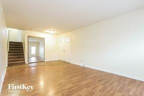 Lansing house for rent - a living room with wood floors and white walls and a staircase