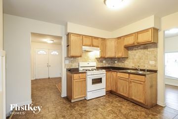 Lansing house for rent - a kitchen with wooden cabinets and a white stove