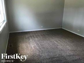 Midlothian house for rent - a gray carpeted room with white walls and a window