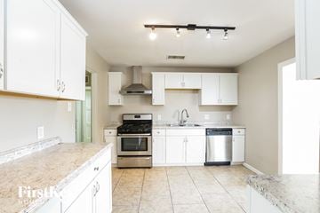 Phoenix house for rent - a large kitchen with white cabinets and stainless steel appliances