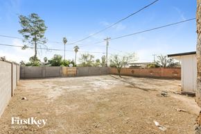 Phoenix house for rent - a yard with dirt and a fence and some trees