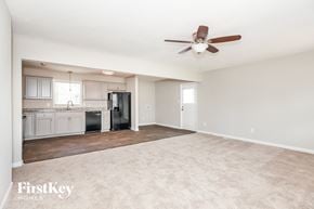 Gastonia house for rent - an empty living room and kitchen with a ceiling fan