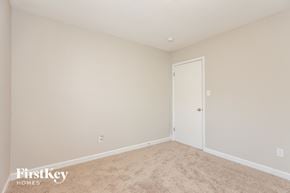 Gastonia house for rent - a bedroom with beige carpet and a white door
