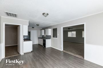 Garland house for rent - A spacious living room with a kitchen in the background and a doorway leading to another room.