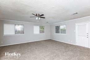Garland house for rent - A spacious room with a ceiling fan and carpeted floor.