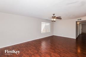 Phoenix house for rent - an empty living room with wood floors and a ceiling fan