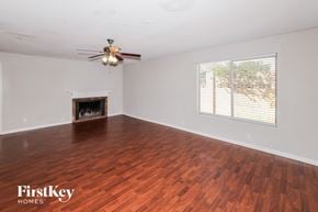 Phoenix house for rent - a living room with wood flooring and a fireplace and a ceiling fan