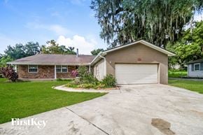 Apopka house for rent - a brick house with a driveway and a garage door