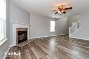 Indianapolis house for rent - A spacious room with a fireplace and wooden flooring.