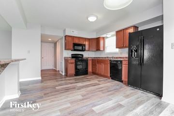 Indianapolis house for rent - A kitchen with wooden cabinets and black appliances.