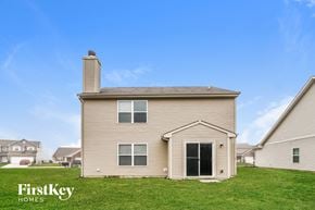 Indianapolis house for rent - A house with a beige exterior and a chimney is for sale by FirstKey Homes.