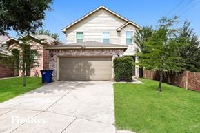 Dallas house for rent - a home with a garage with a driveway and a brick house