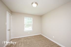 Dallas house for rent - a bedroom with carpet and a white door and a window