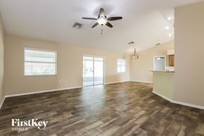 Lakeland house for rent - A spacious room with wooden flooring and a ceiling fan.