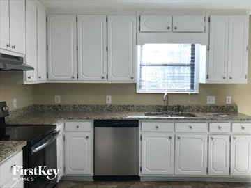 Powder Springs house for rent - A kitchen with white cabinets and a granite countertop.