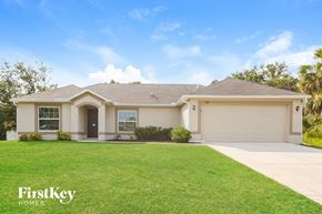 North Port house for rent - A house with a well-maintained lawn and a clear blue sky above.
