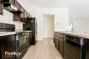 North Port house for rent - A kitchen with black appliances and wooden floors.