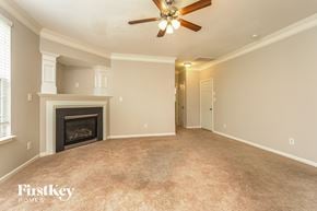 Winston-Salem house for rent - A spacious room with a fireplace and a ceiling fan.
